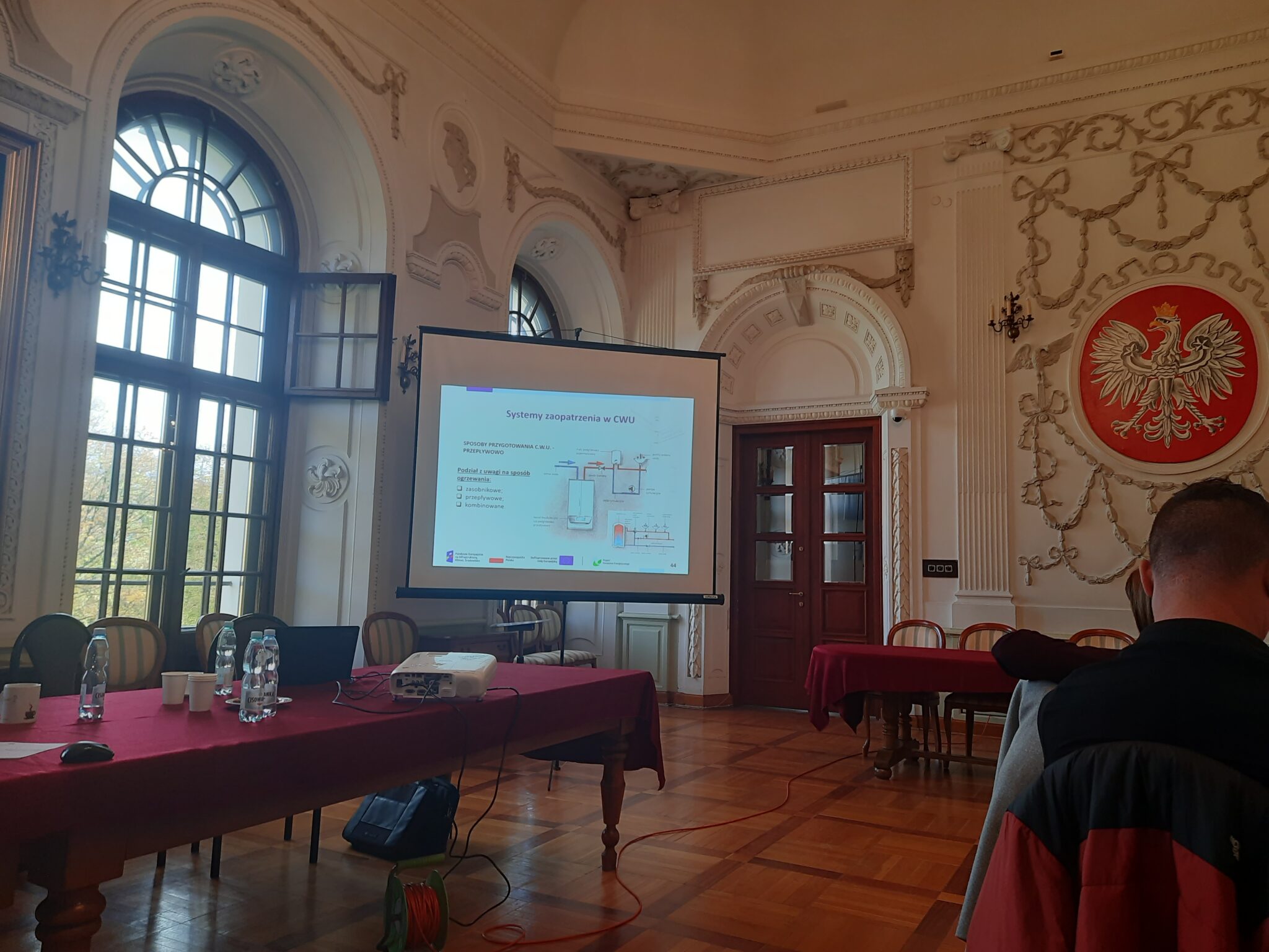 Wnętrze Sali Rycerskiej Starostwa Powiatowego w Lubartowie wraz z wyświetlaną prezentacją w trakcie szkolenia dla Doradców klimatycznych prowadzonego przez Doradców Energetycznych z Wojewódzkiego Funduszu Ochrony Środowiska i Gospodarki Wodnej w Lublinie w dniu 28 październik 2024