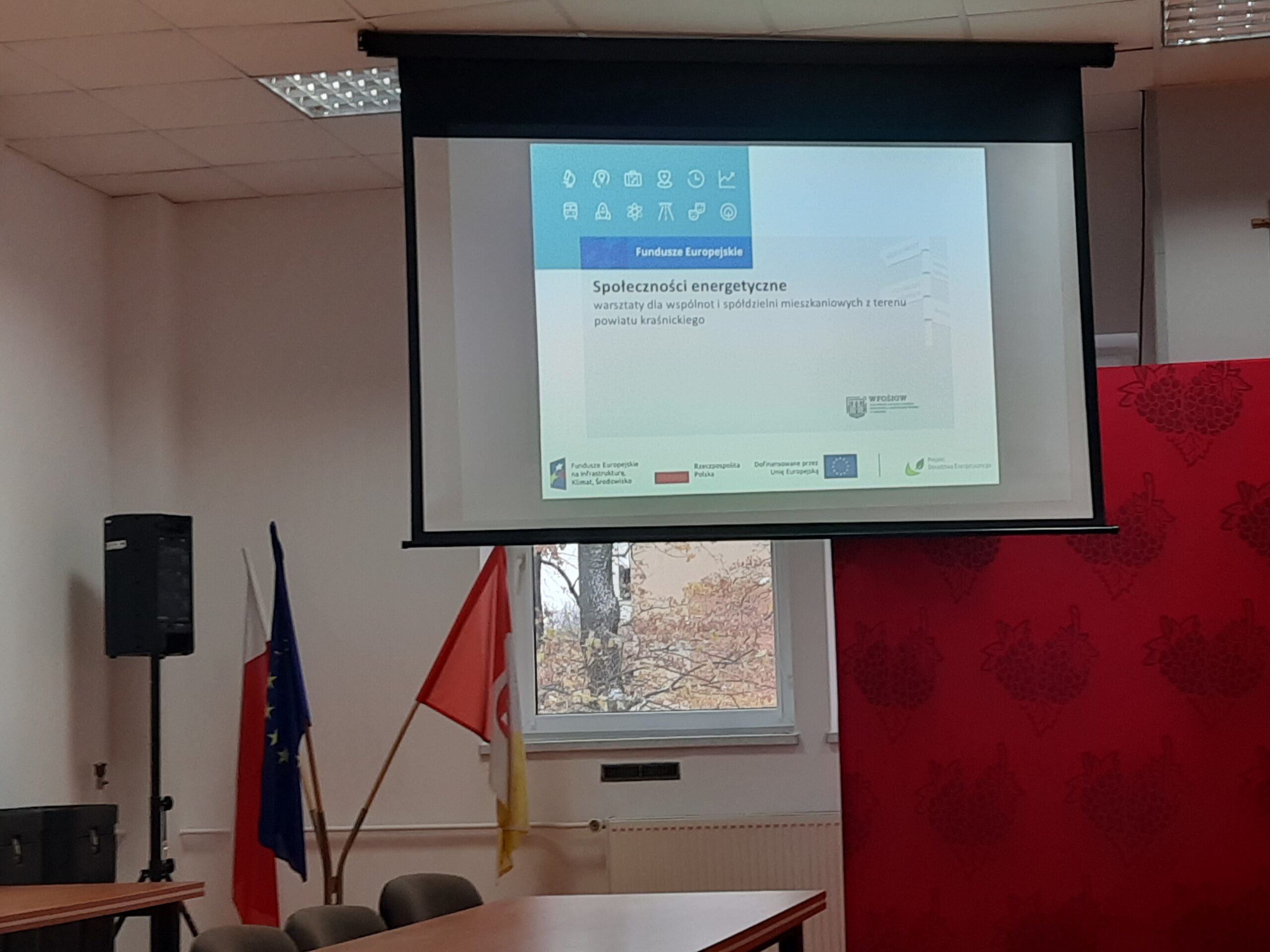 Wnętrze Sali konferencyjnej Zespołu Szkół N3 w Kraśniku podczas warsztatów zorganizowanych dla Spółdzielni i Wspólnot Mieszkaniowych wraz z wyświetlaną prezentacją (w oddali) w dniu 22 listopada 2024