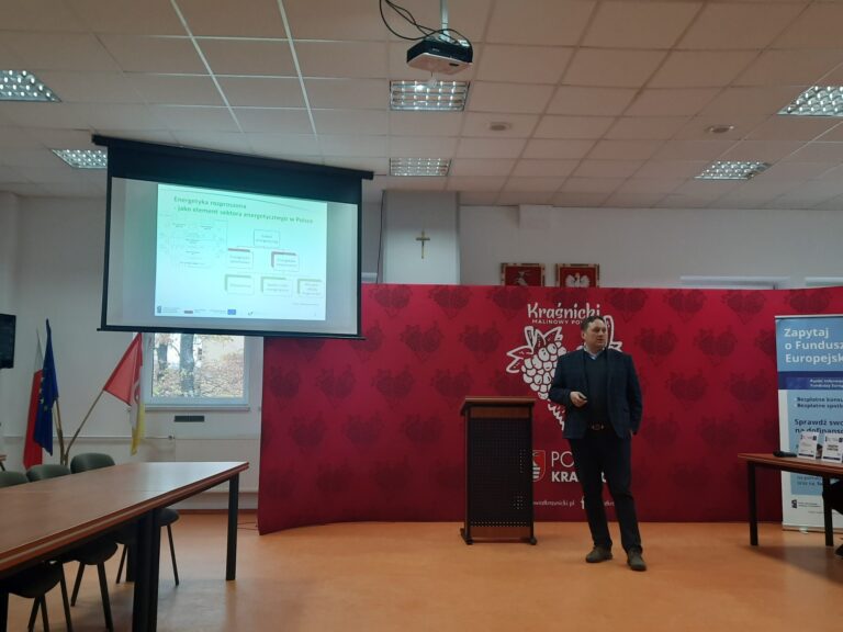 Wnętrze Sali konferencyjnej Zespołu Szkół N3 w Kraśniku podczas warsztatów zorganizowanych dla Spółdzielni i Wspólnot Mieszkaniowych wraz z wyświetlaną prezentacją prelegenta Kajetana Kościka – Koordynator Zespołu Doradców Energetycznych, Wojewódzki Fundusz Ochrony Środowiska i Gospodarki Wodnej w Lublinie w dniu 22 listopada 2024