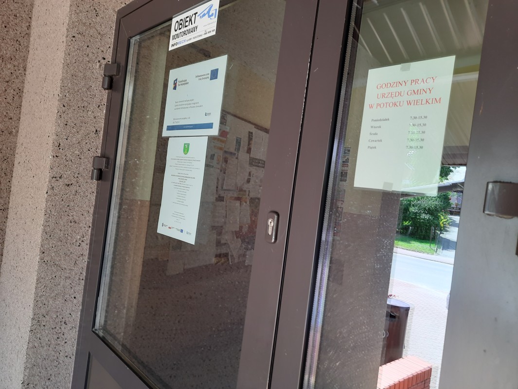 Plakat - Powiat Janowski realizuje projekt: System doradztwa sprzyjający
osiągnięciu neutralności klimatycznej w Powiecie Janowskim wraz z zaproszeniem na
bezpłatne konsultacje wywieszony na drzwiach wejściowych budynku Urzędu Gminy Potok
Wielki