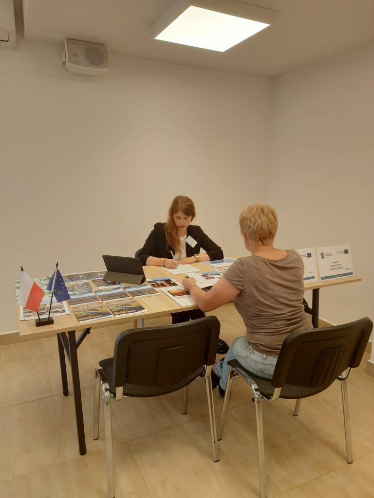 Doradca klimatyczny wraz interesantem udzielający bezpłatnych konsultacji w zakresie neutralności klimatycznej w sali konferencyjnej podczas realizacji Mobilnego Punktu Doradztwa Klimatycznego w Urzędzie Gminy Godziszów w dniu 11 czerwiec 2025