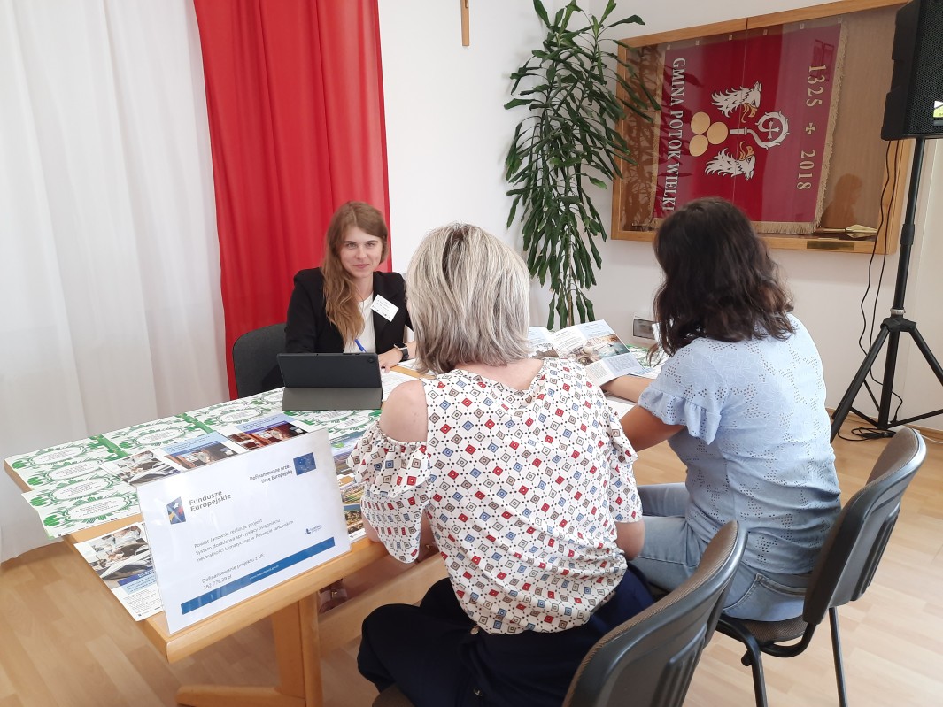 Doradca klimatyczny wraz z interesantami udzielający bezpłatnych konsultacji
w zakresie neutralności klimatycznej w sali narad podczas realizacji Mobilnego Punktu
Doradztwa Klimatycznego w Urzędzie Gminy Potok Wielki w dniu 25 czerwiec 2025