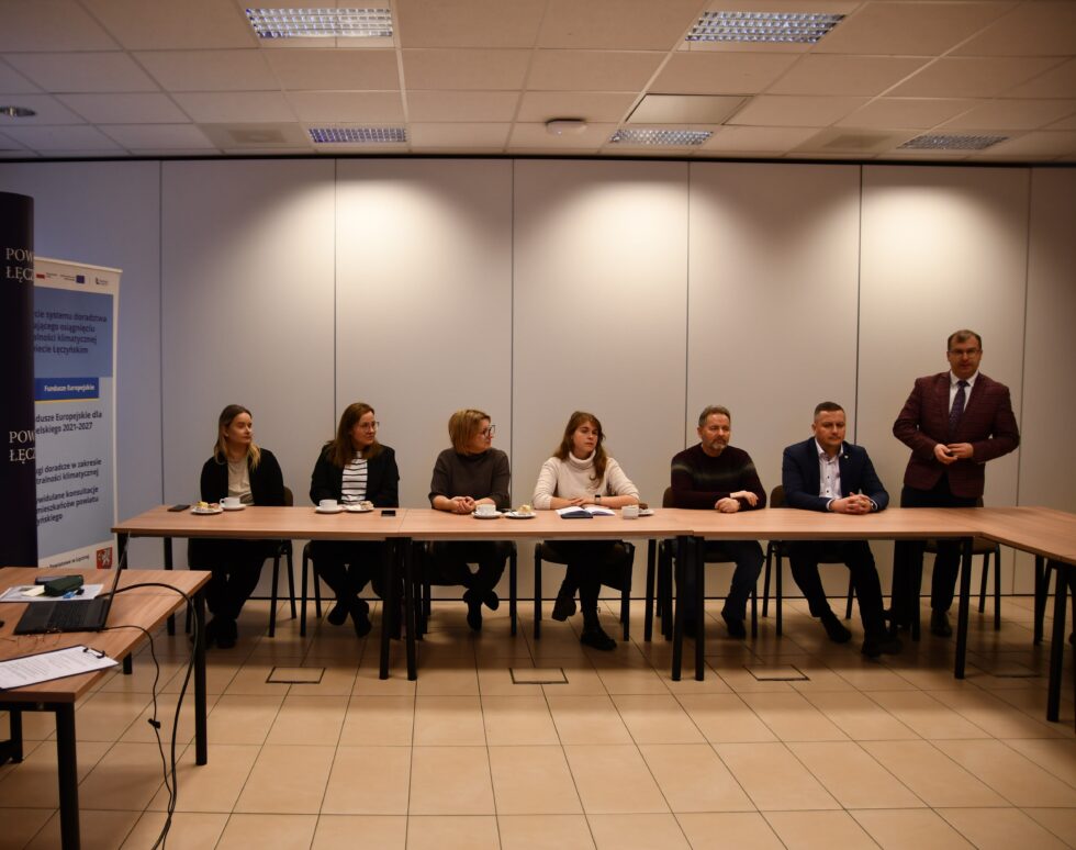 Wspólne zdjęcie na zajmowanych stanowiskach przez mieszkańców i przedsiębiorców z Powiatu Łęczyńskiego wraz z Doradcą klimatycznym z Powiatu Janowskiego podczas przemówienia Daniela Słowika – Starosty Powiatu Łęczyńskiego na szkoleniu w Sali Konferencyjnej Starostwa Powiatowego w Łęcznej w dniu 12 grudnia 2024- w oddali.
