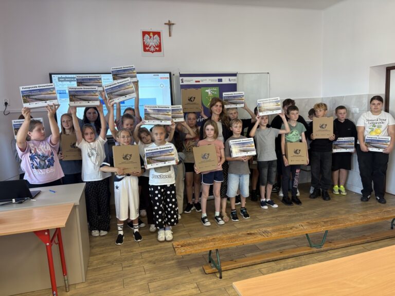 Wspólne zdjęcie Doradcy klimatycznego wraz z uczestnikami spotkania edukacyjnego podczas spotkania edukacyjnego pt. „Mały gest – wielki efekt dla klimatu” w Publicznej Szkole Podstawowej im. im. Bohaterów Września 1939 w Dzwoli w dniu 9 września 2026 roku z wręczonymi gadżetami ekologicznymi.