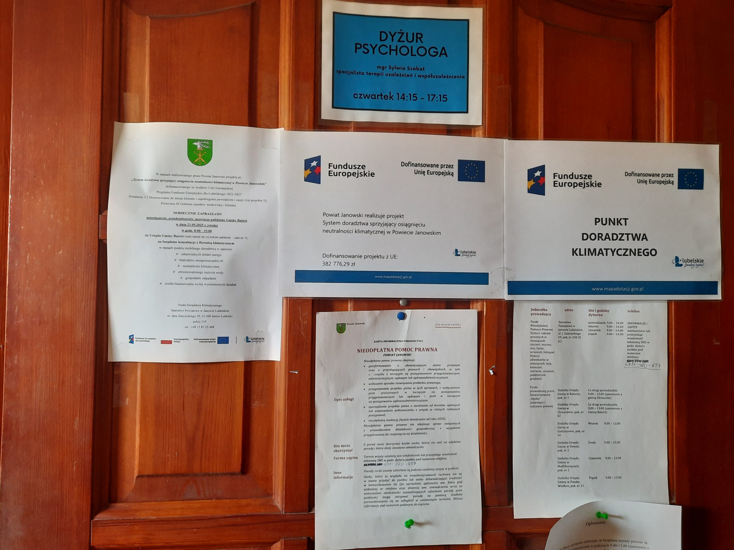 Plakat - Powiat Janowski realizuje projekt: System doradztwa sprzyjający osiągnięciu neutralności klimatycznej w Powiecie Janowskim wraz plakatem Doradztwa Klimatycznego oraz zaproszeniem na bezpłatne konsultacje wywieszony na drzwiach sali narad Urzędu Gminy Batorz